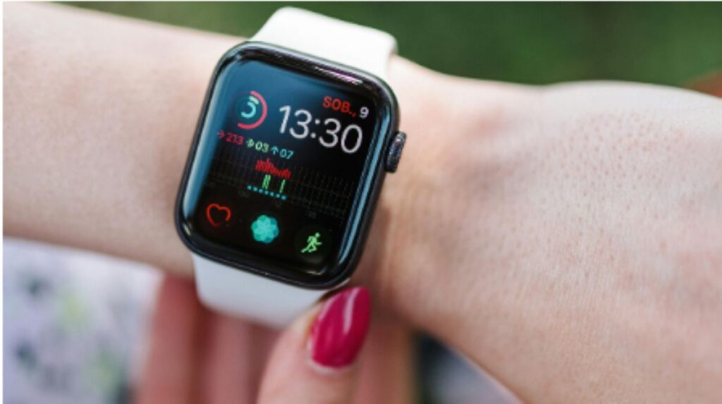Smartwatch on wrist showing heart rate and activity metrics.

